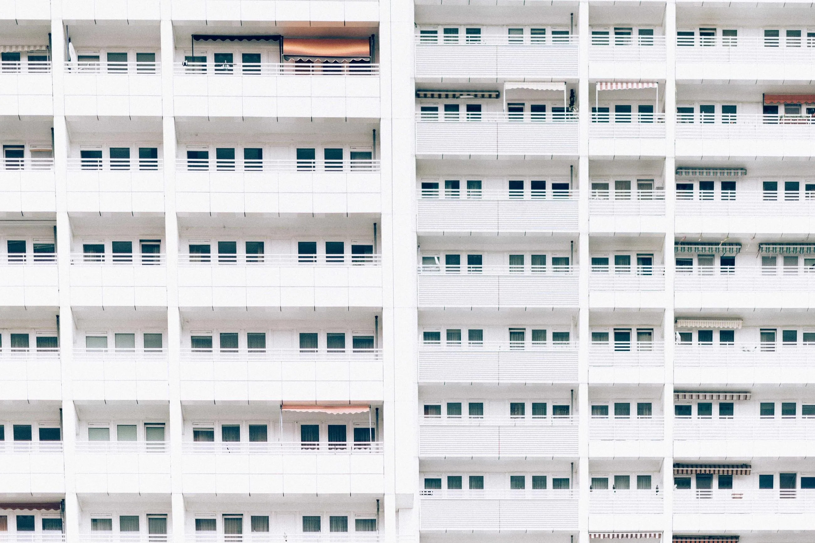 A white apartment block, its windows repeating in a strict grid.